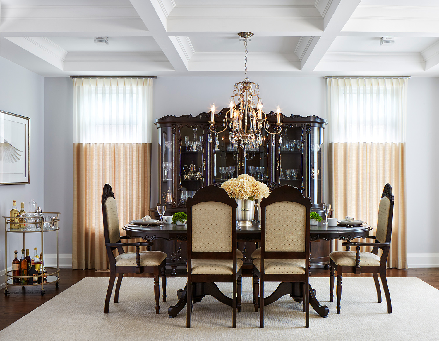 The project dining room showcasing a family heirloom table and hutch with two tone window drapery and a small liquor cart.