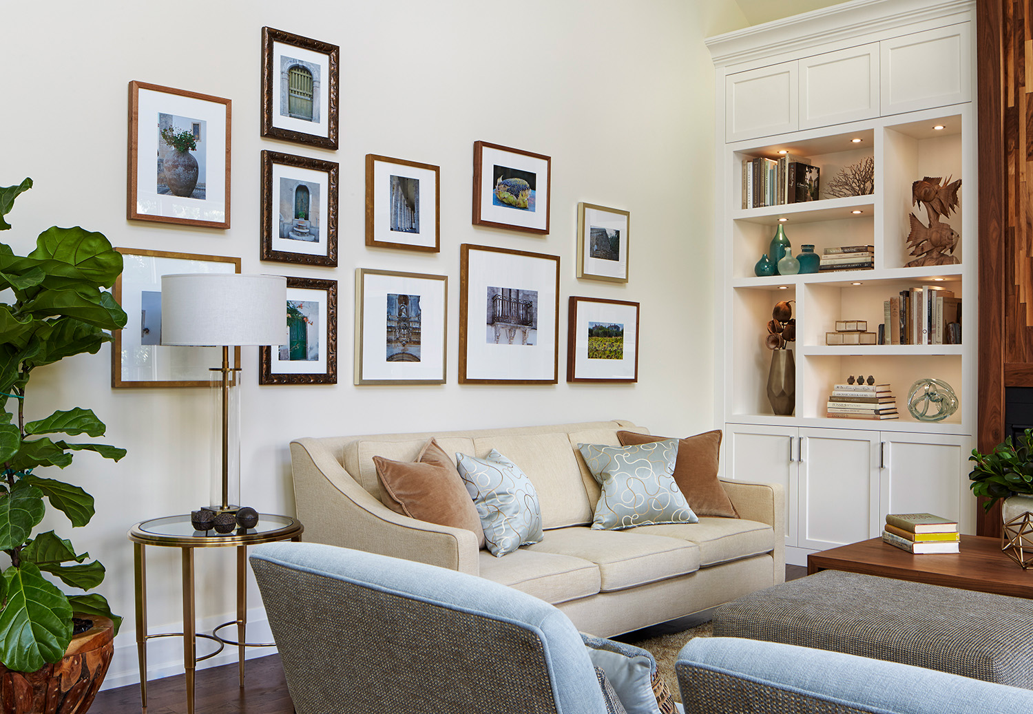 The project living room showing a sofa with toss cushions, the bookcase, and a feature wall with beautifully displayed photographs.