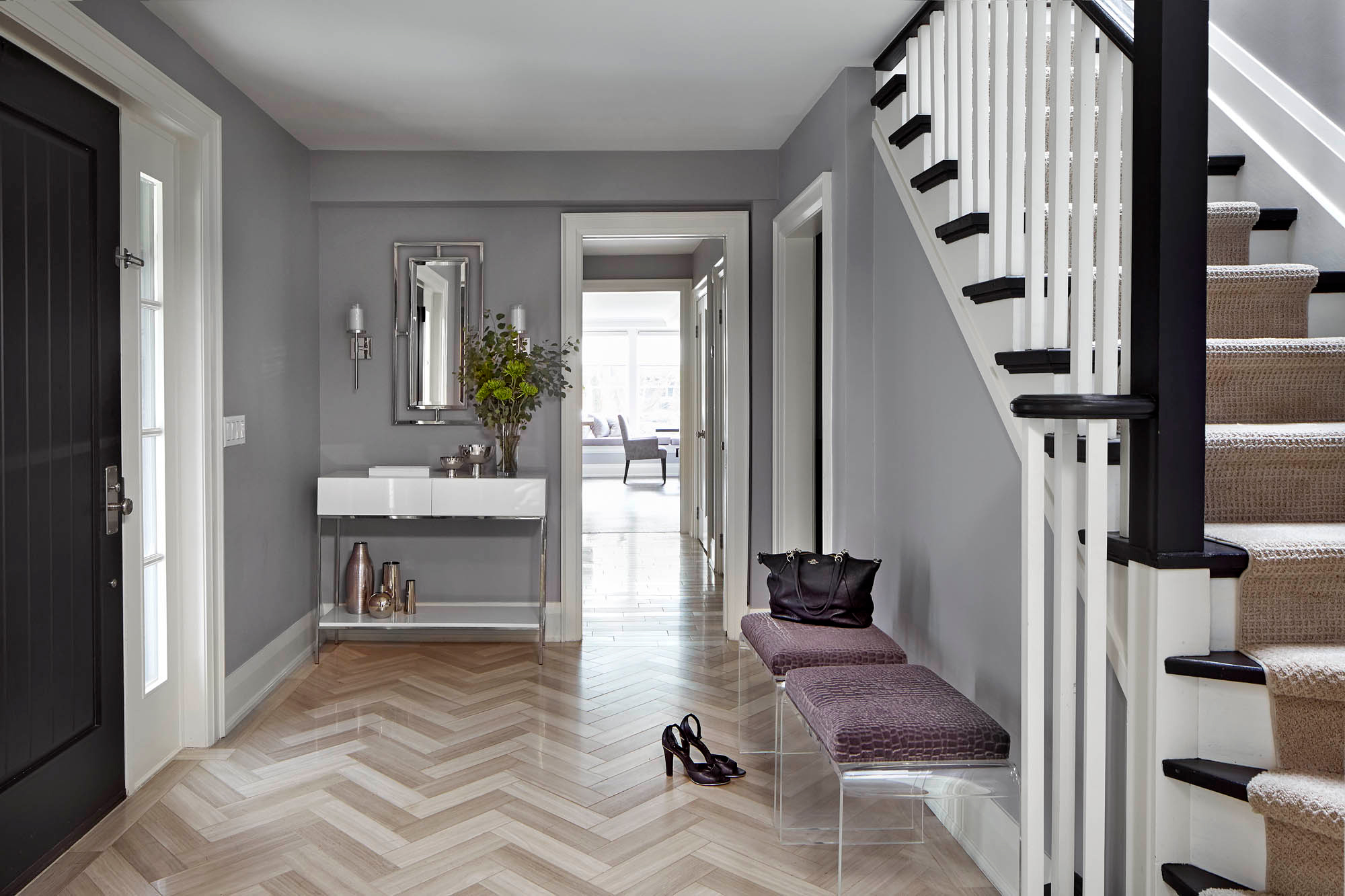 NUITH – FIFTY SHADES OF DIOR GRAY – FRONT ENTRY DESIGNED BY CELIA ALIDA RUTTE – PHOTOS BY DONNA GRIFFITH A front entry designed in purple and purple grey with a white front entry table, a black front door and a herringbone tile pattern on the floor.