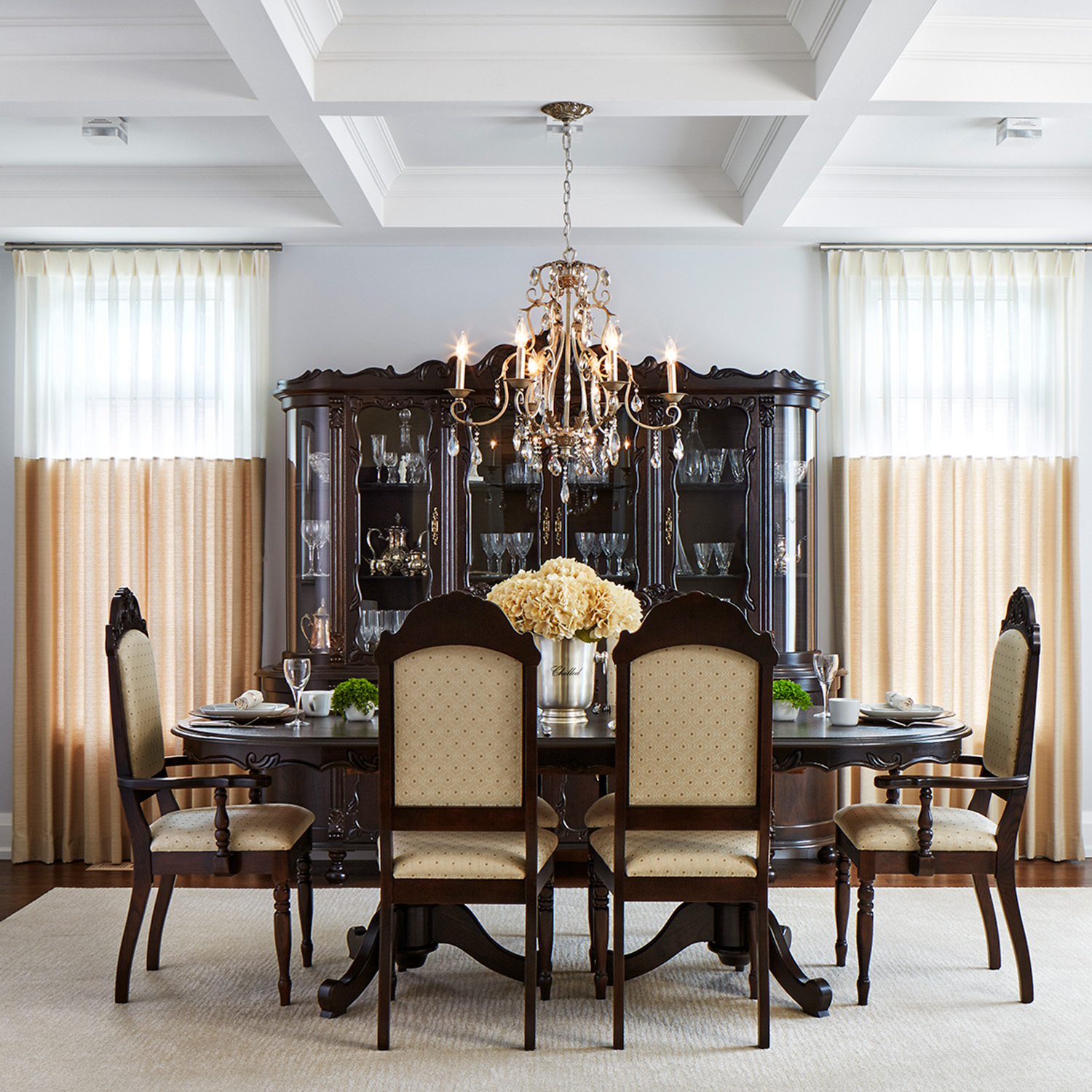The project dining room showcasing a family heirloom table and hutch with two tone window drapery and a small liquor cart.
